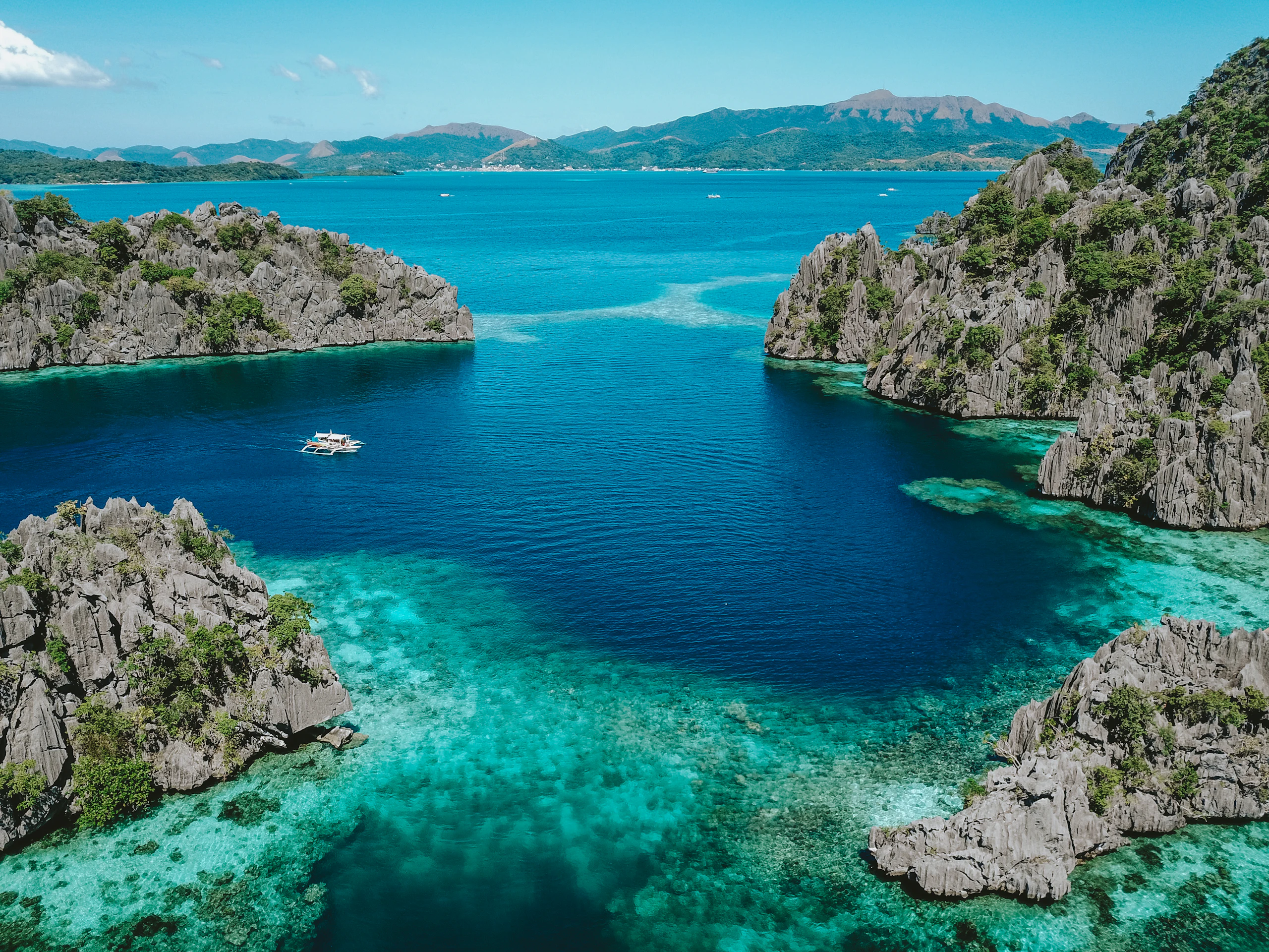 Wooden walkway and green limestone around Kayangan Lake in Coron