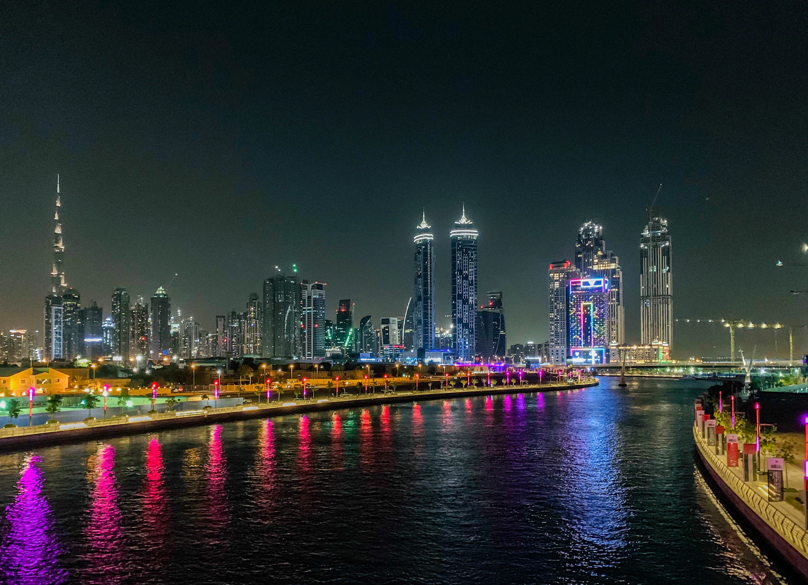 Dubai Water Canal at night, with the Downtown Dubai skyline and Burj Khalifa beyond