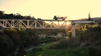 An image of a bus crossing a bridge during sunset.