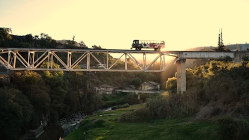 An image of a bus crossing a bridge during sunset.