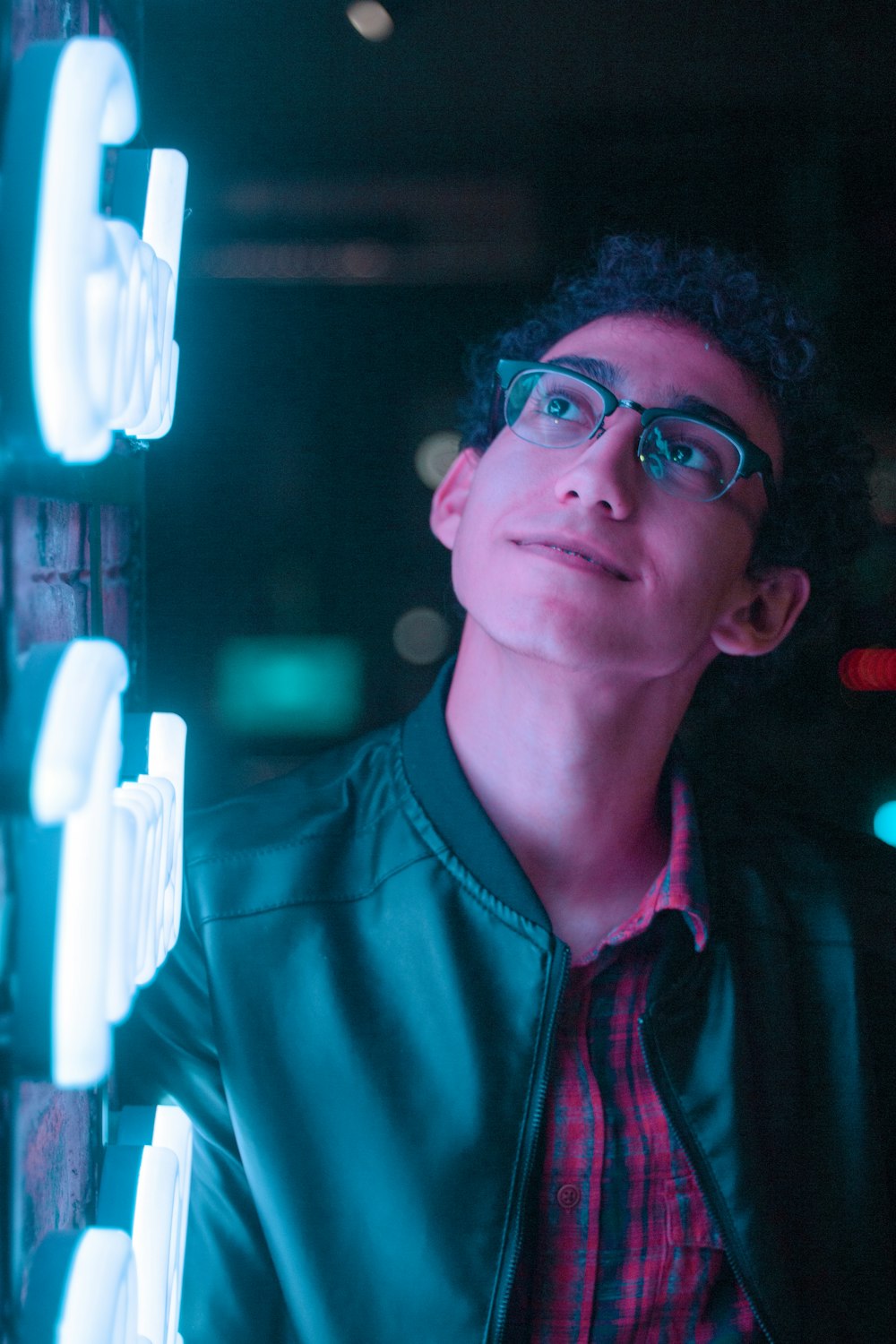 man in eyeglasses wearing jacket looking at the light
