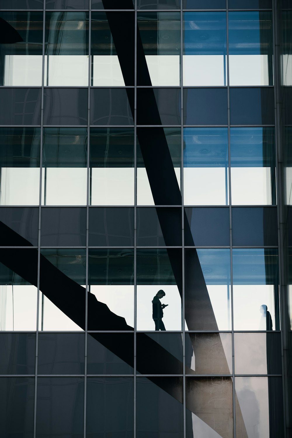 a man standing on a ledge in front of a tall building