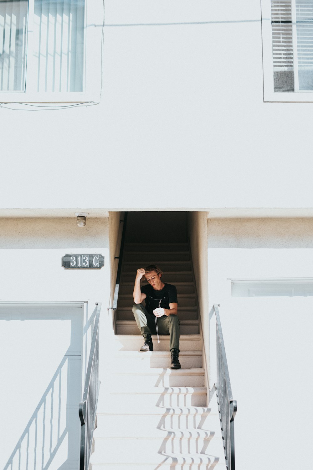 Mann sitzt auf Treppe