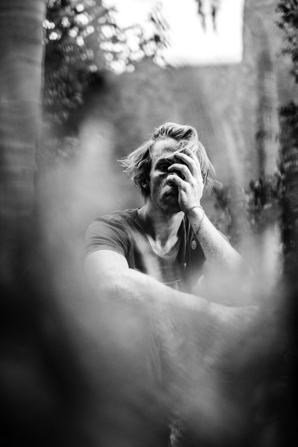 gray scale photo of man covering his face