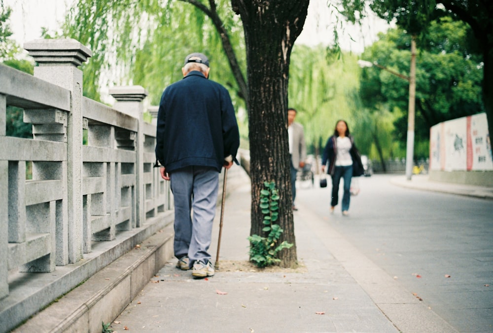 man walking with can beside road