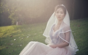 A flowing tulle gown with layered skirts, captured outdoors with gentle sunlight filtering through trees.