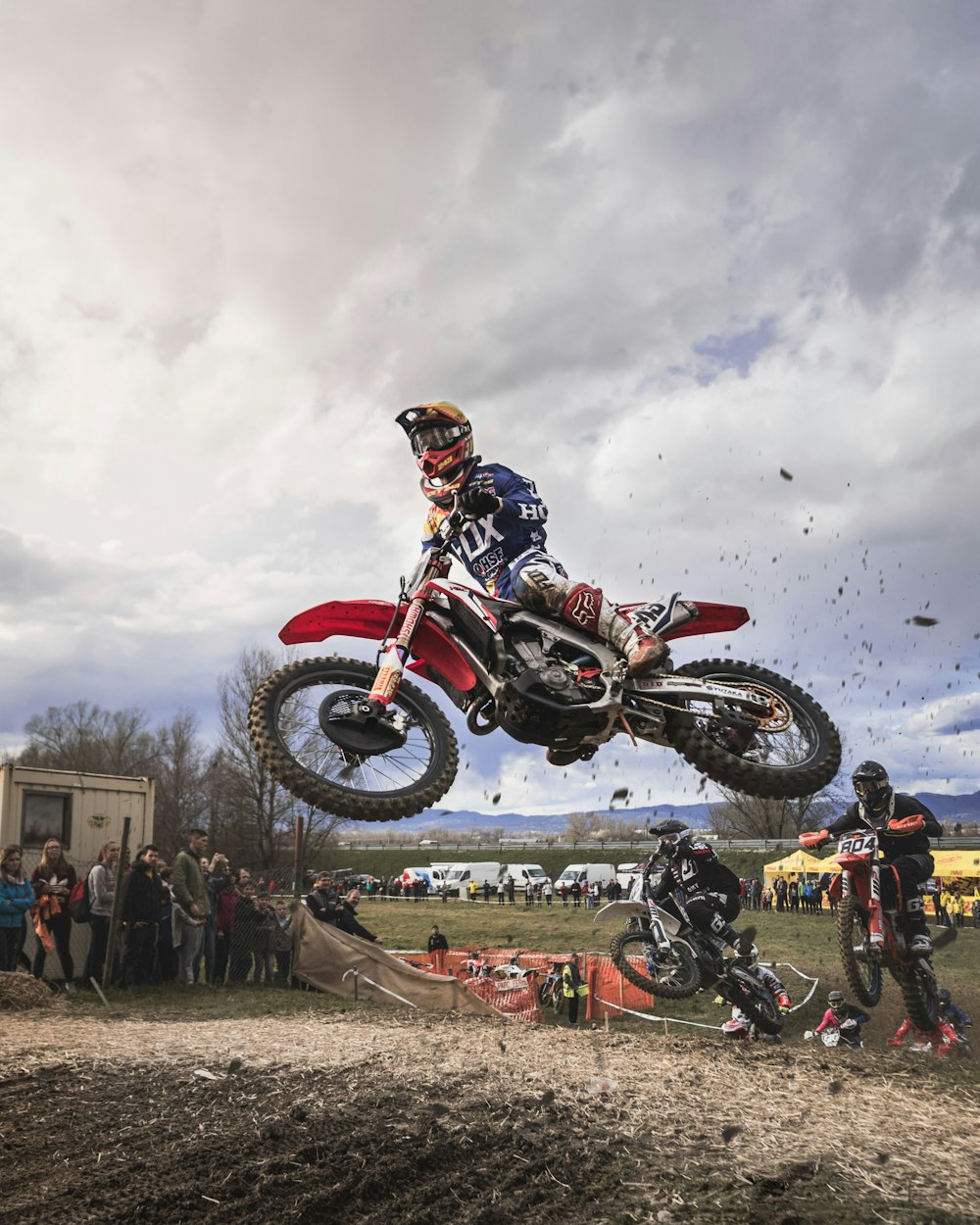 Homem pilotando moto de terra vermelha motocross