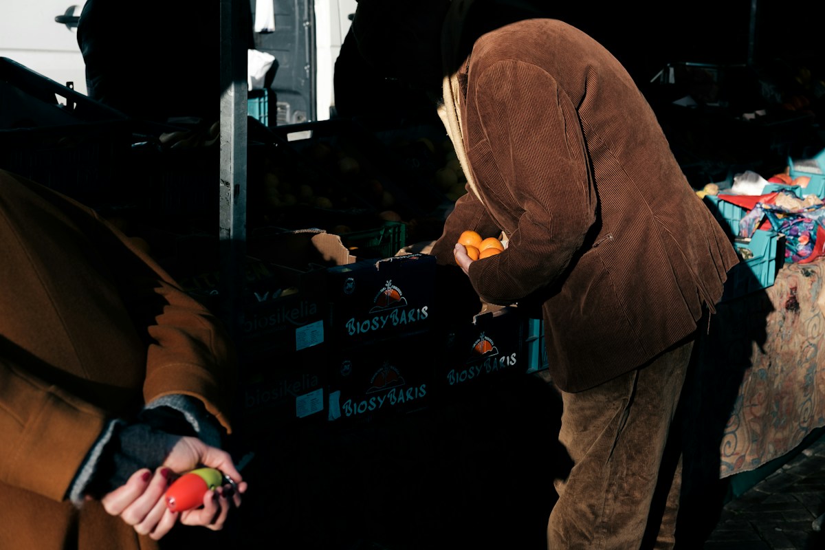 A man and woman stand together, with the woman holding an apple, illustrating community giving projects during the holidays.