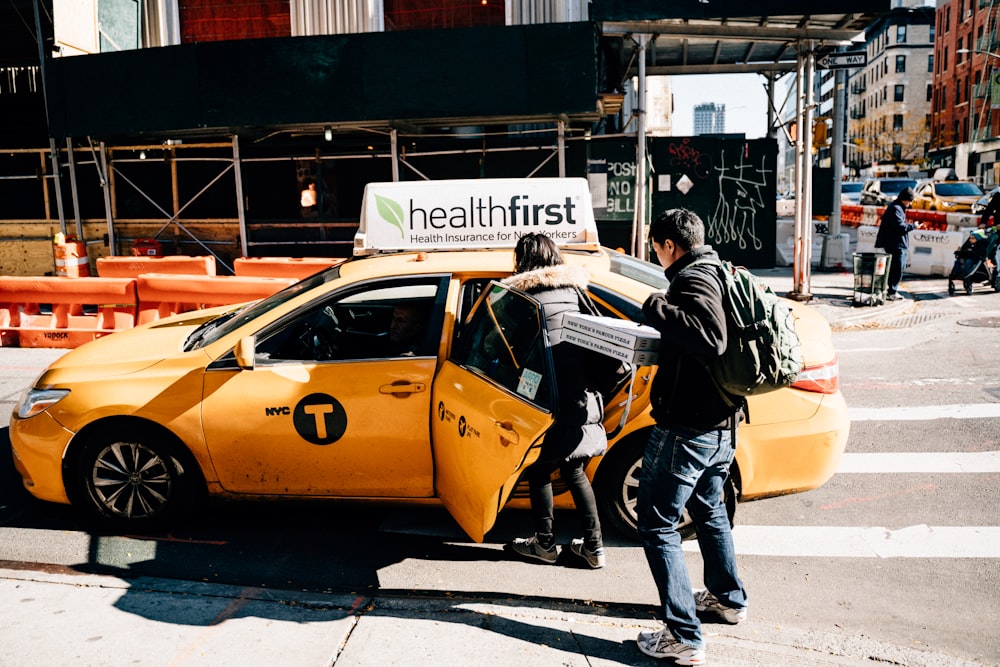 남자와 여자가 노란 택시 근처에 서 있다