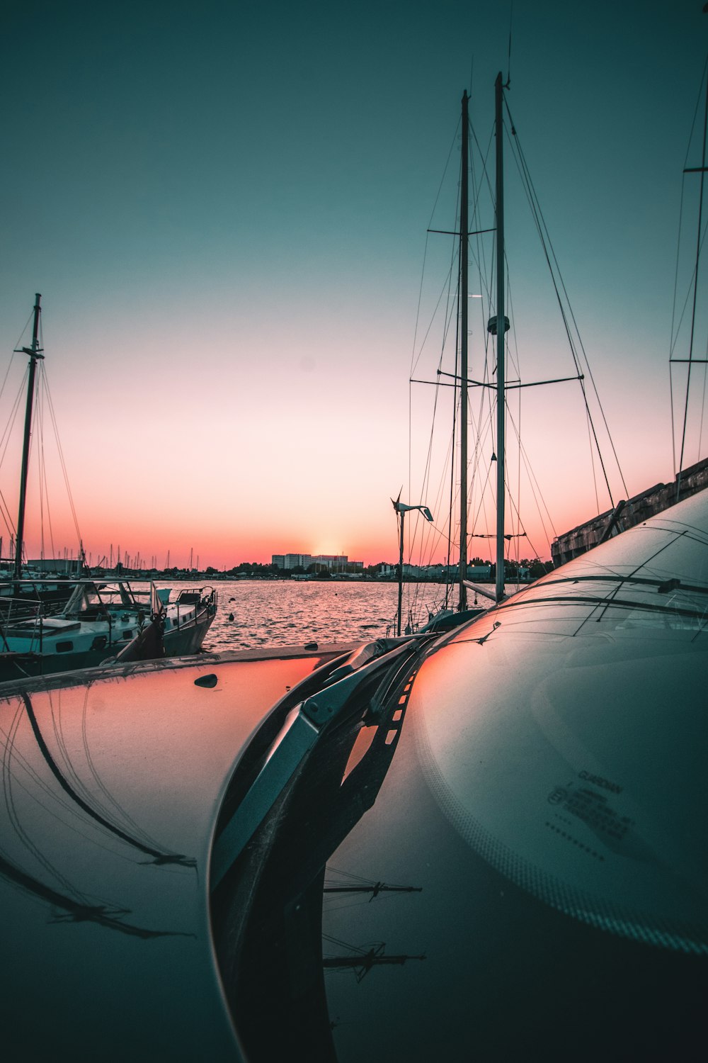 a group of sailboats docked in a harbor at sunset