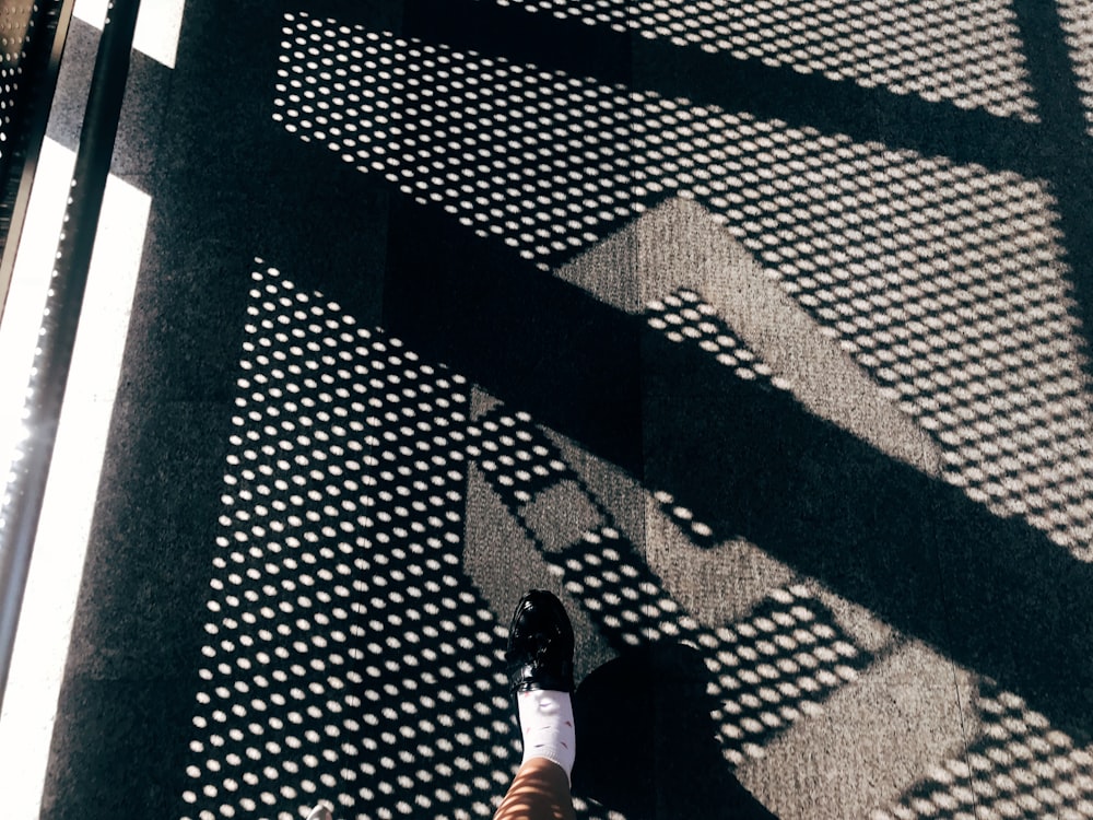 person wearing unpaired black shoe during daytime