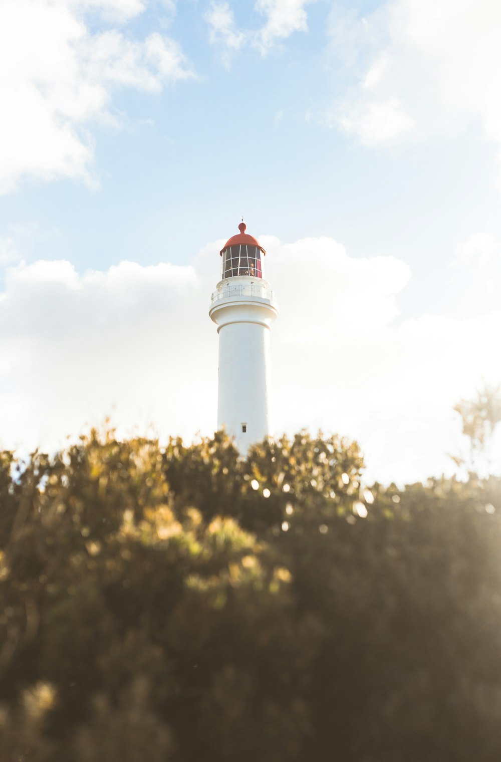 white and red lighthouse under blue sky