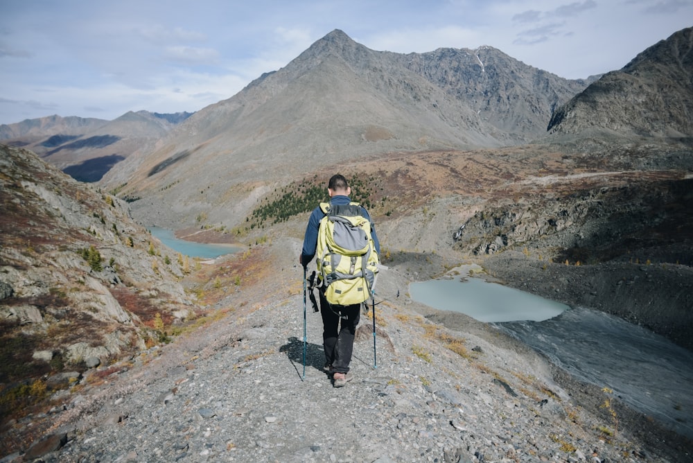 man walking toward mountains during during daytime