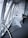 An architectural interior with angular geometric designs featuring a staircase flanked by metal railings. The space is defined by the convergence of modern materials like glass and concrete, highlighted by the interplay of light and shadows.