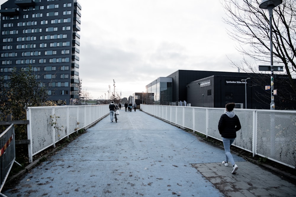 person walking near white fence