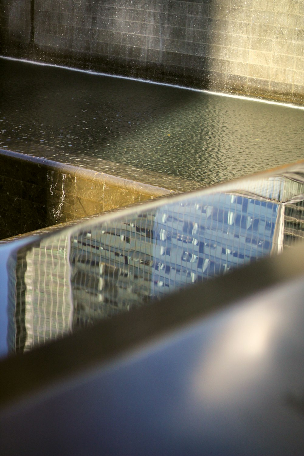 um reflexo de um edifício em uma piscina de água