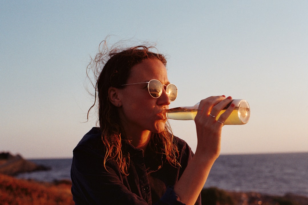 foto de mulher bebendo cerveja na praia