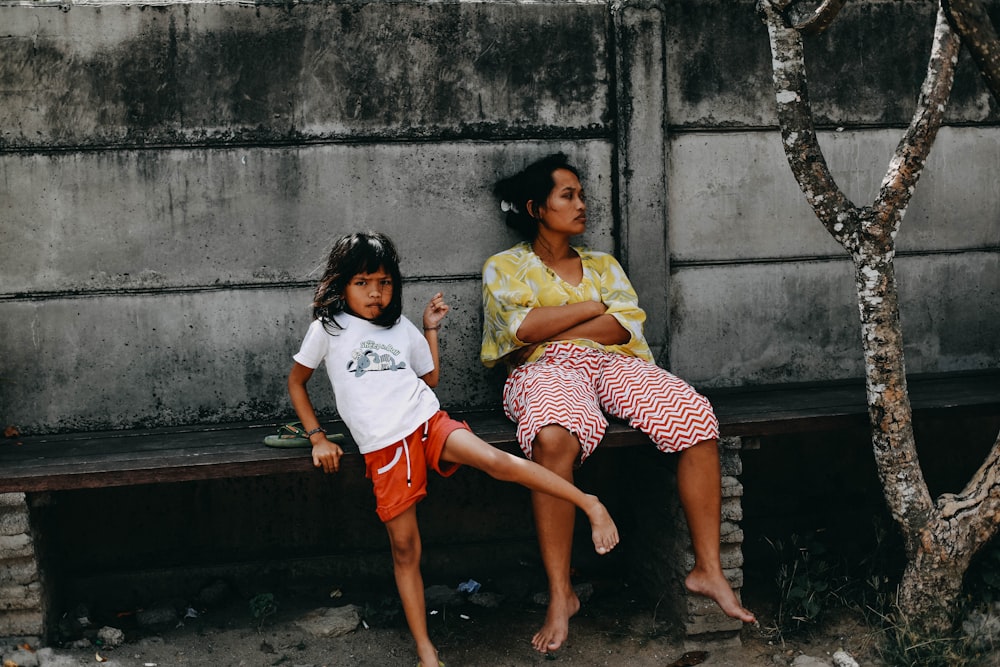 woman and girl sitting on bench