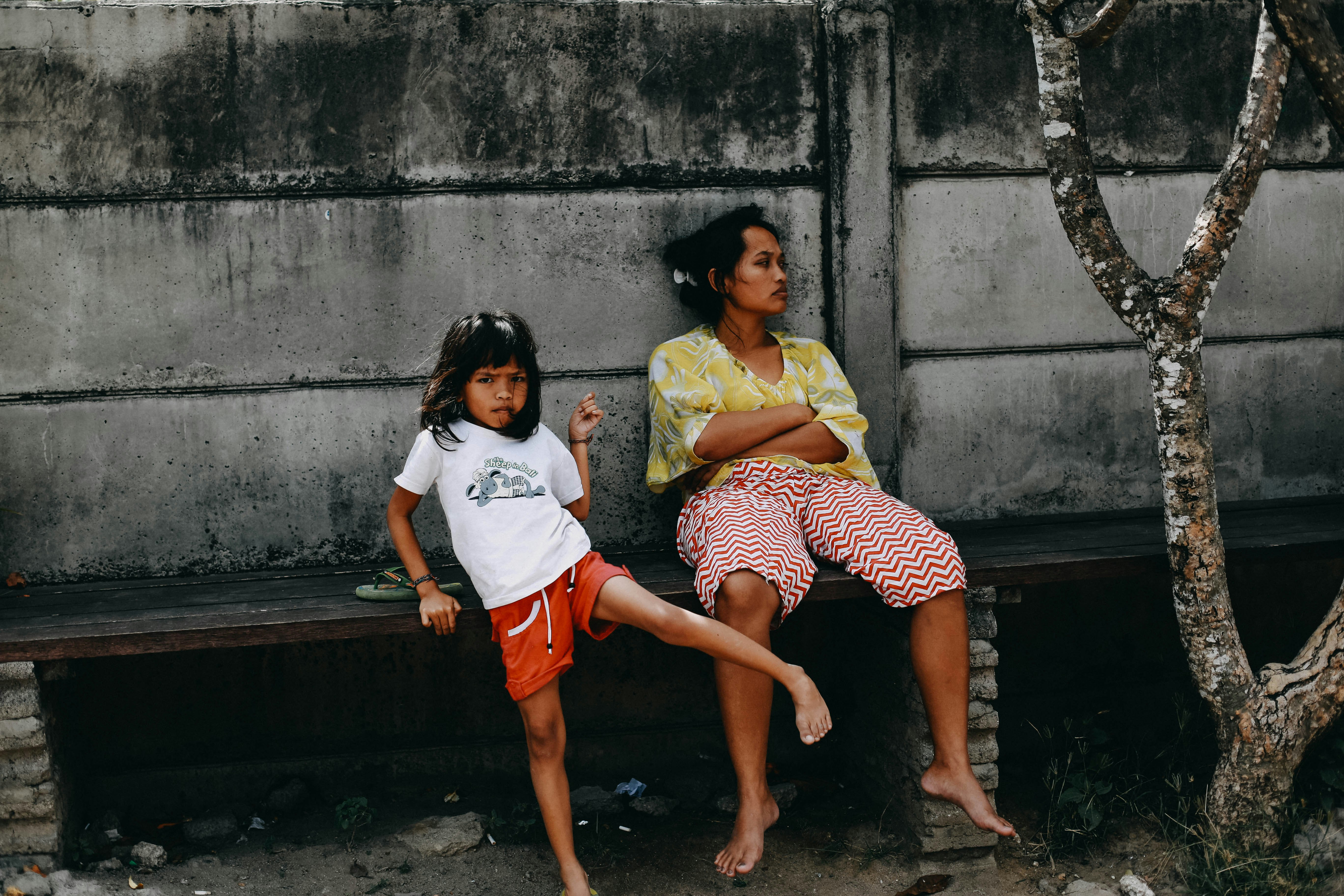 woman and girl sitting on bench