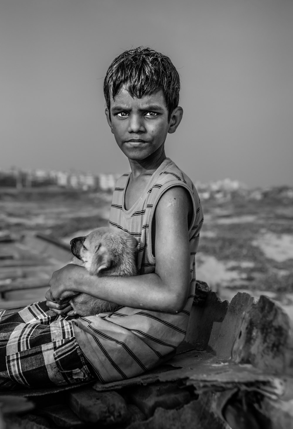 grayscale photography of boy carrying dog