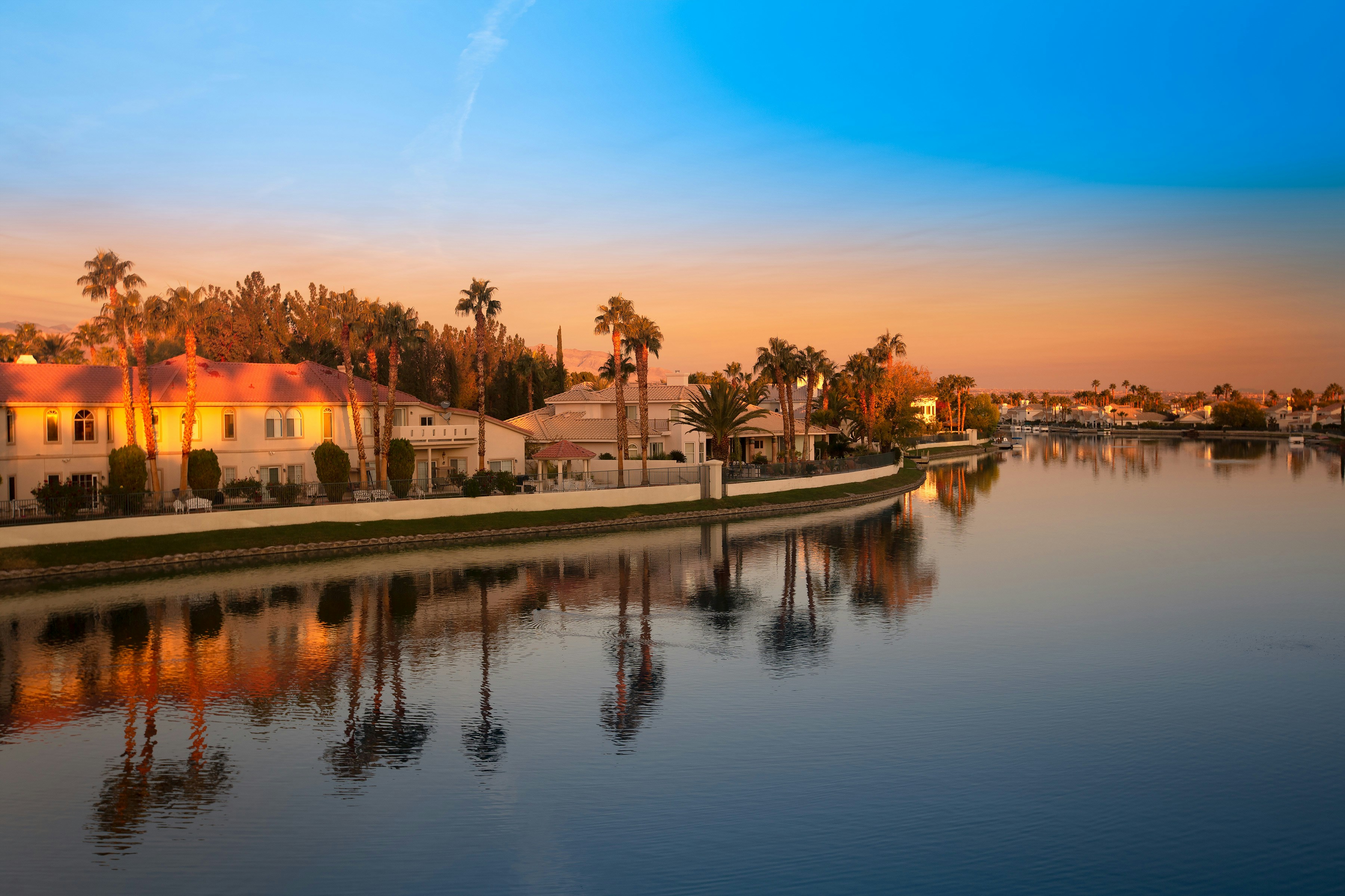 Calm Florida waterfront scene at sunset, warm golden light on water, peaceful residential property visible