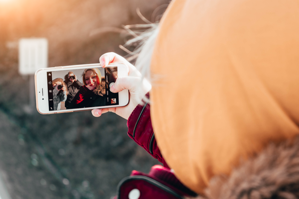 person taking selfie on her gold iPhone 6