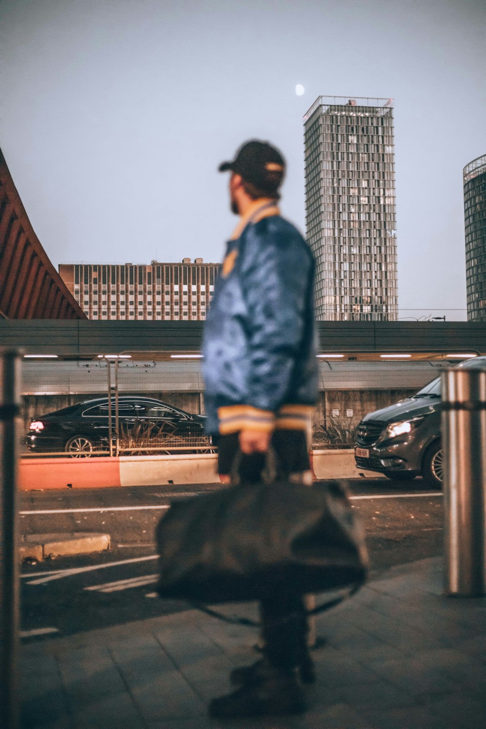 a man standing on a sidewalk holding a bag