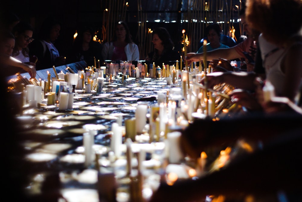 people lighting candles during night time