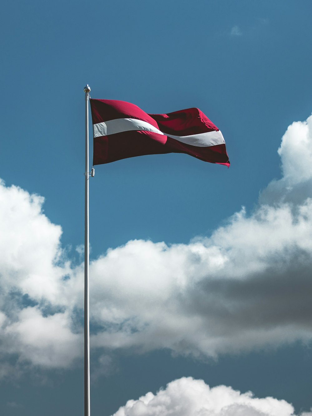 waving red and white striped flag on pole