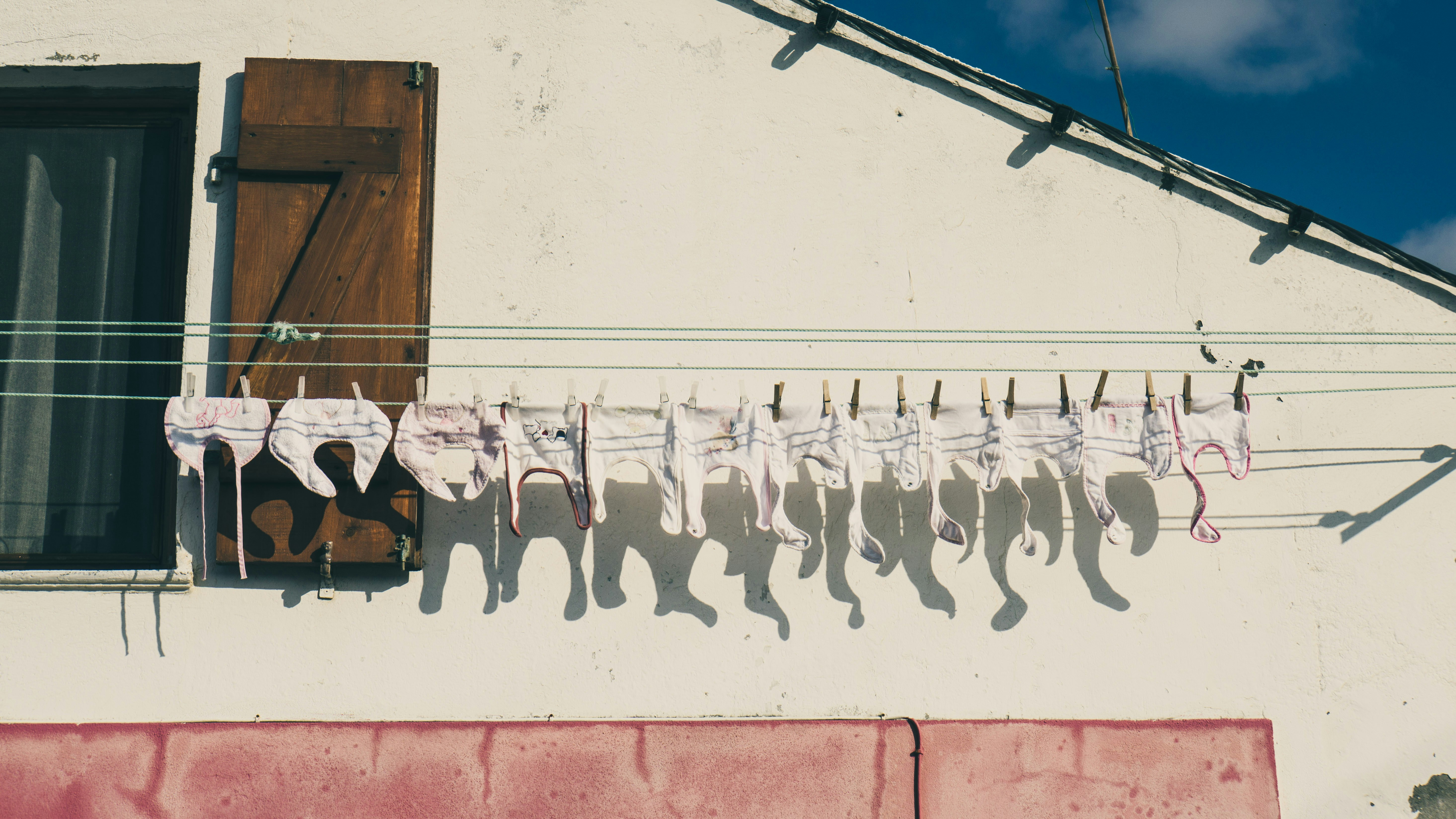 baby's white clothes hanged on white clothes rack