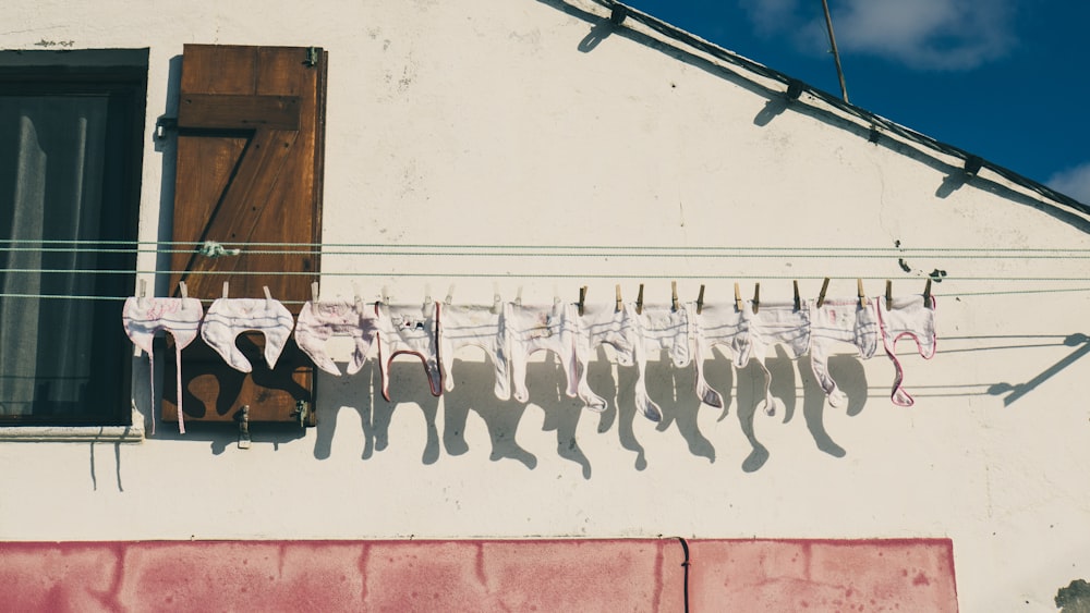 baby's white clothes hanged on white clothes rack