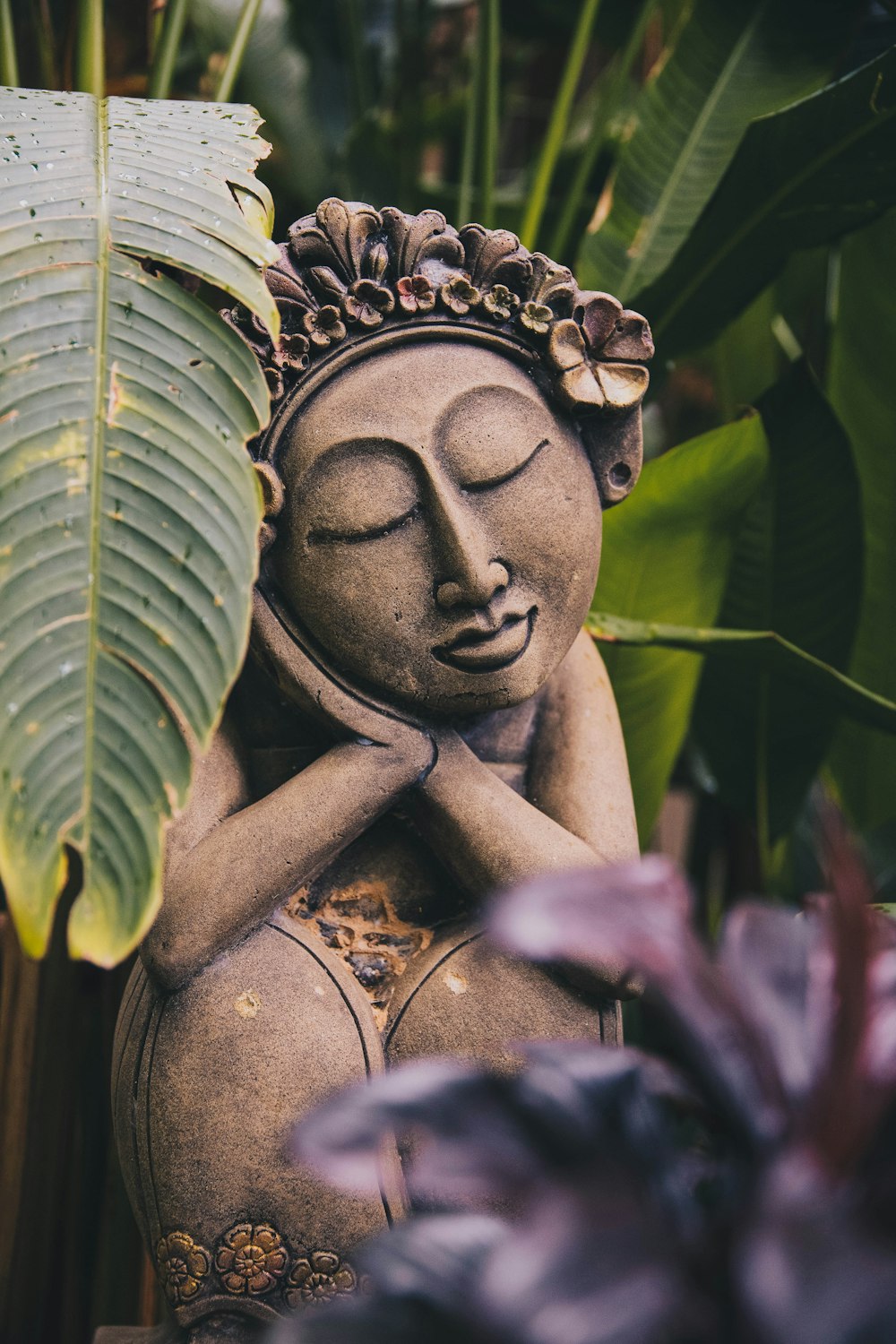 Statue de Bouddha endormi près de la plante verte