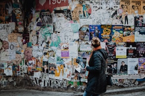 person standing beside wall during daytime