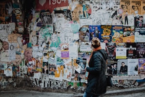 person standing beside wall during daytime