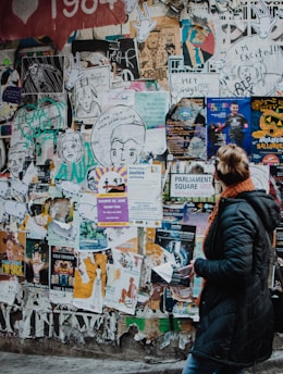 person standing beside wall during daytime