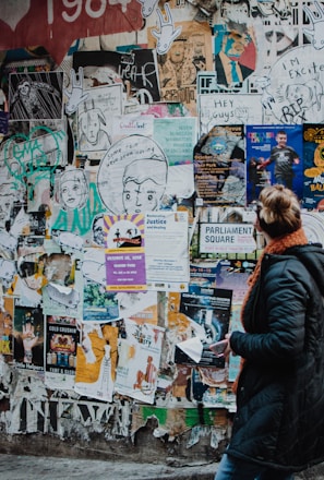 person standing beside wall during daytime