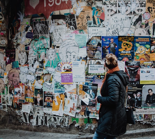 person standing beside wall during daytime