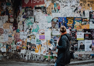 person standing beside wall during daytime