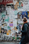 person standing beside wall during daytime