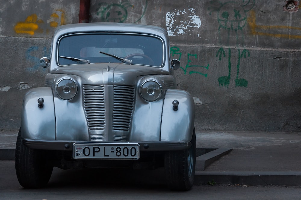 classic silver car parked beside curb