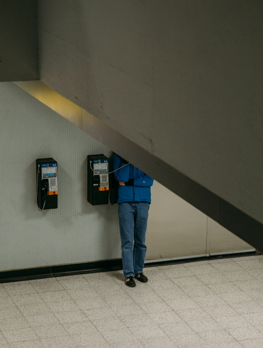 person standing near telephone booth