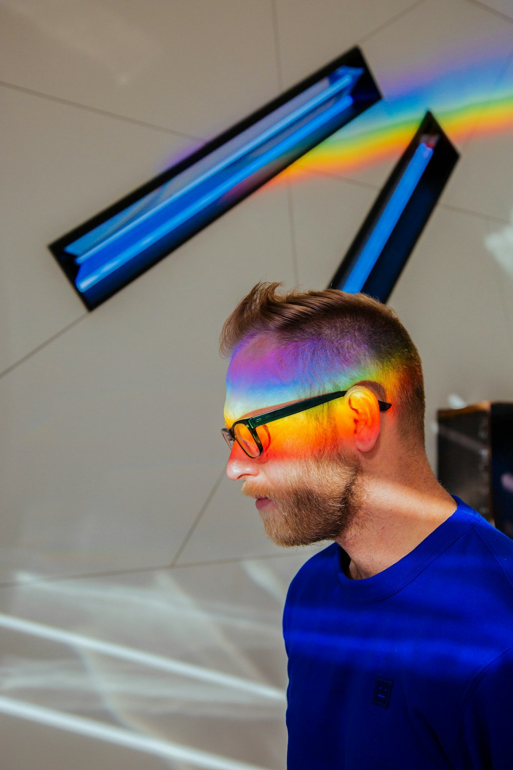 man with multiple colors reflected on his face