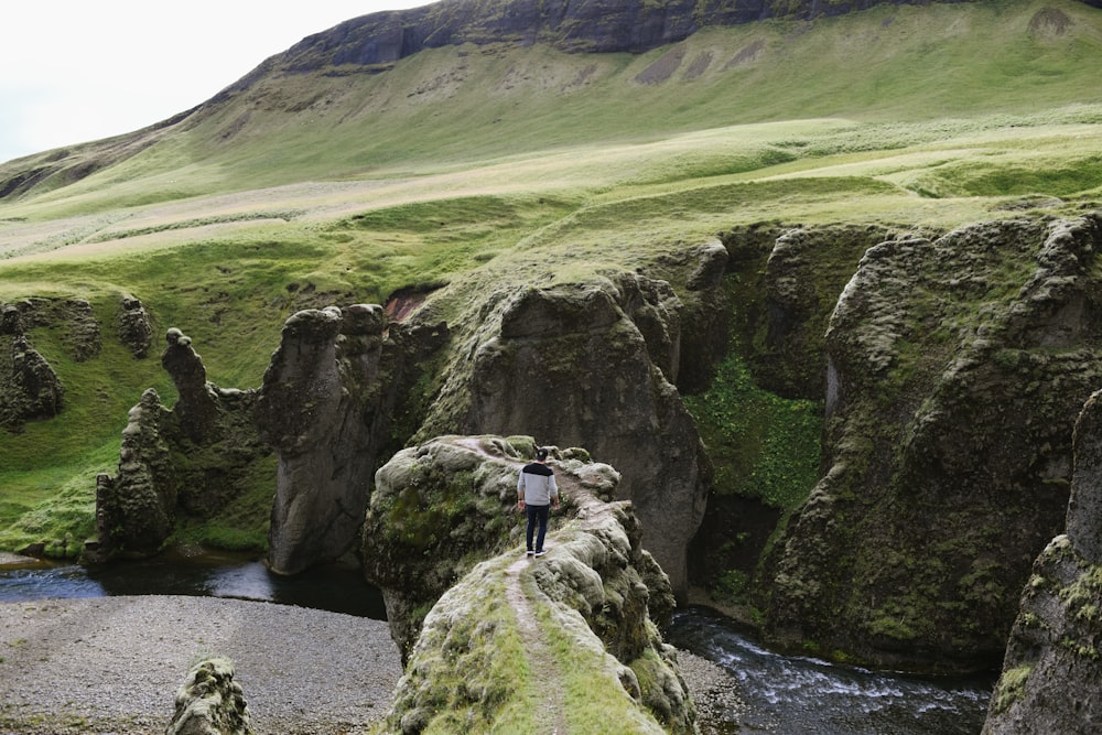 person in white and black top standing on cliff during daytime