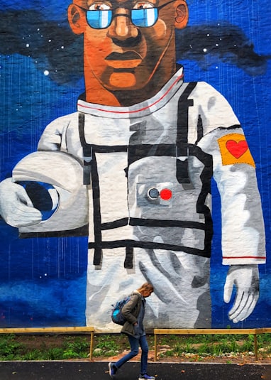 man wearing white astronaut suit painting