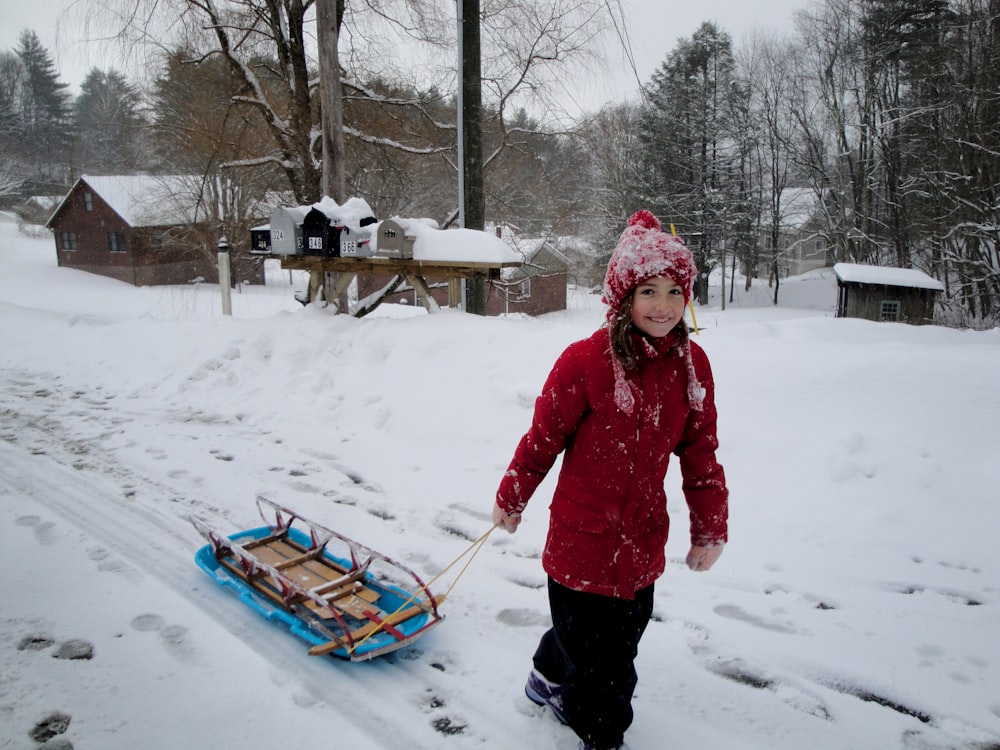 girl about to carry brown and blue toboggan