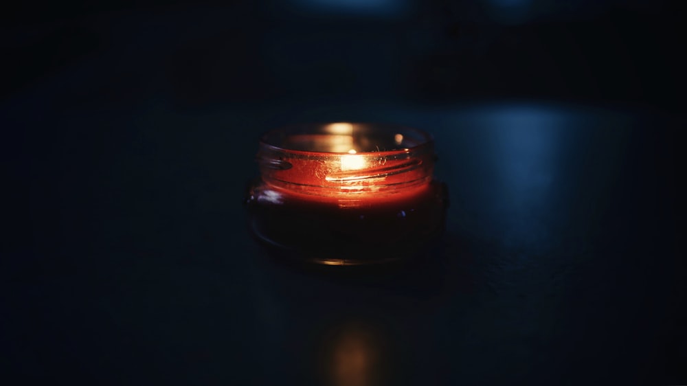 black and red votive candle with flame