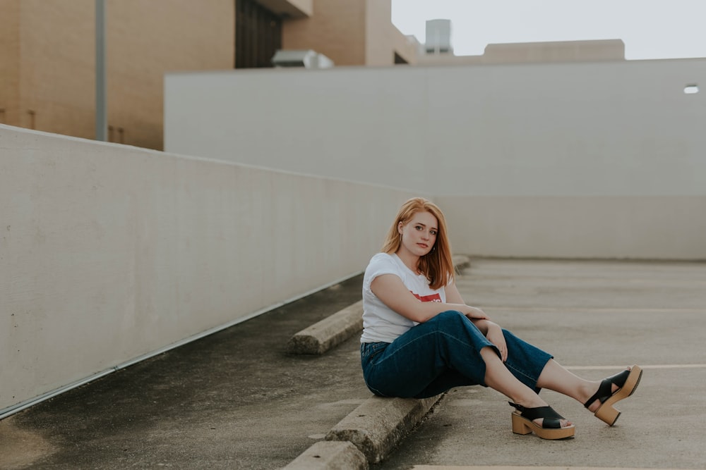 woman sitting on concrete pavement in building