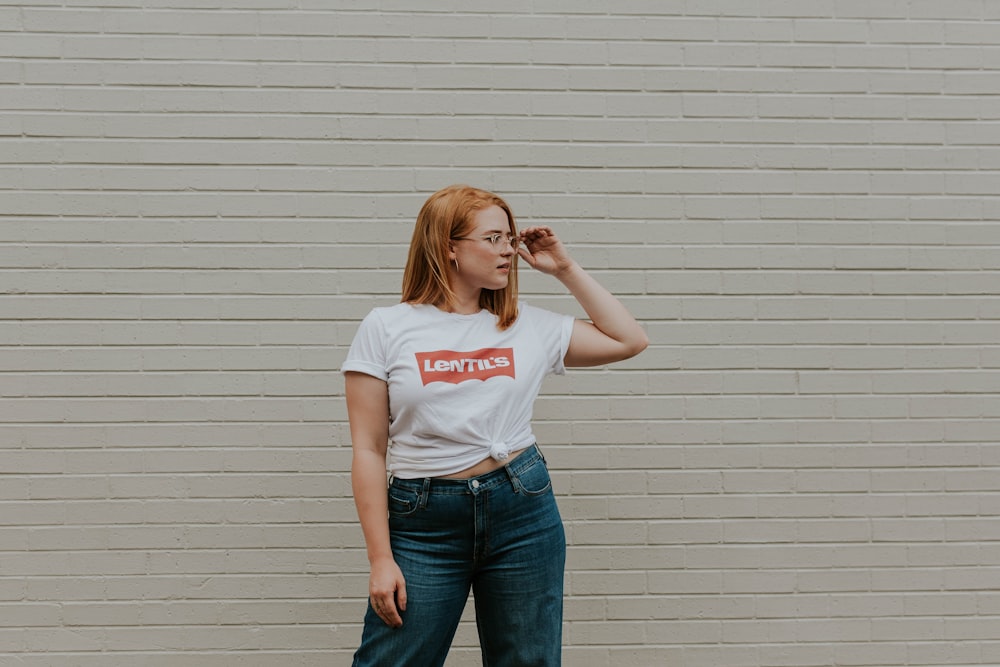 woman wearing white crew-neck shirt and blue-wash denim bottoms