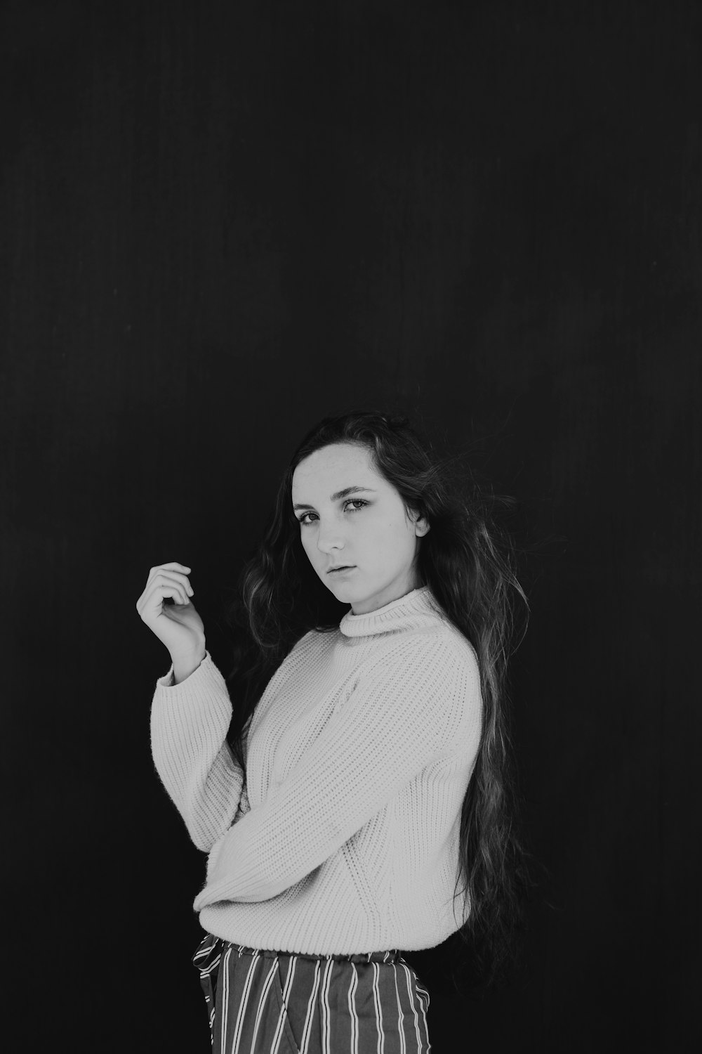 woman wearing white turtleneck sweater in black background