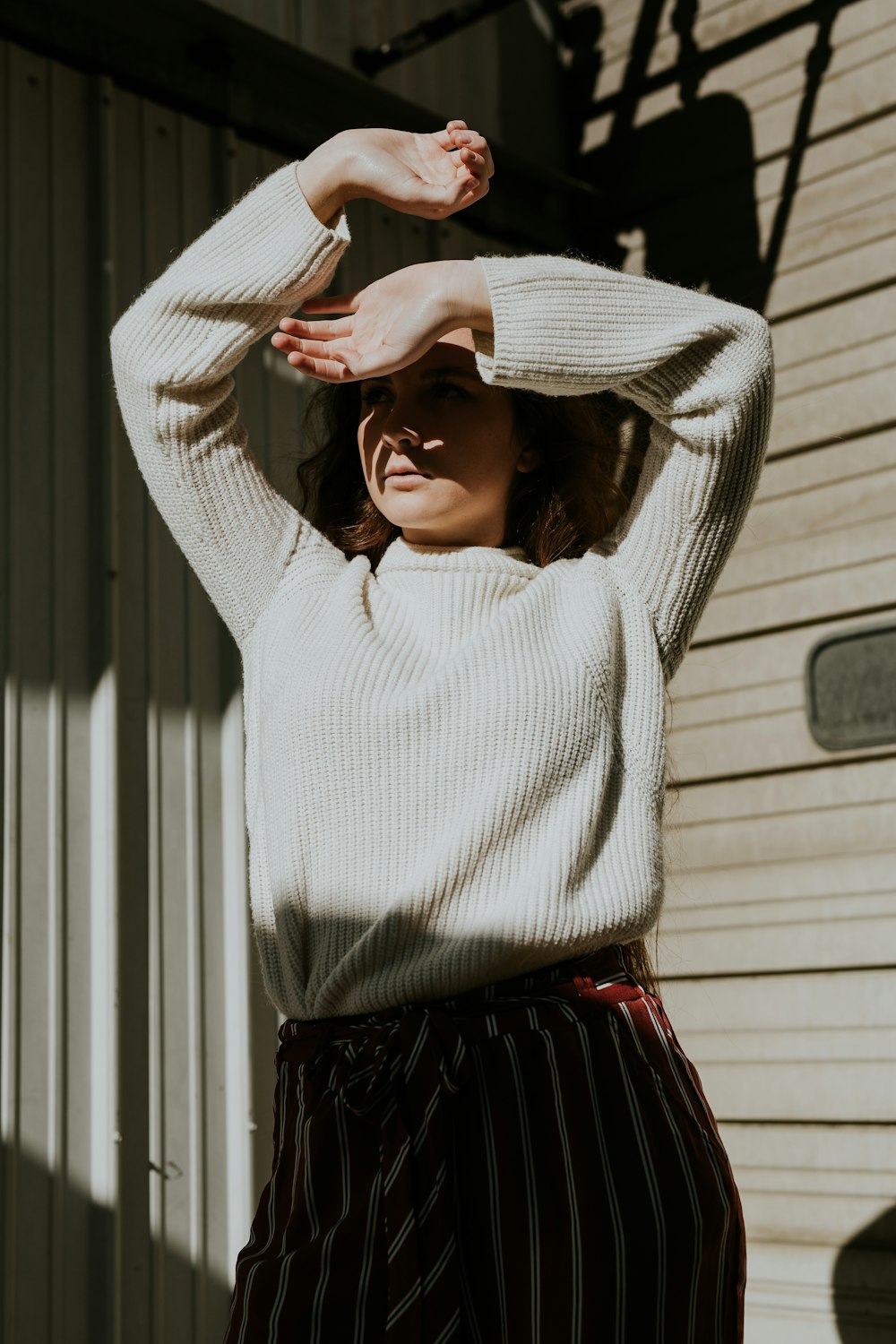 woman posing covering her face from sun rays